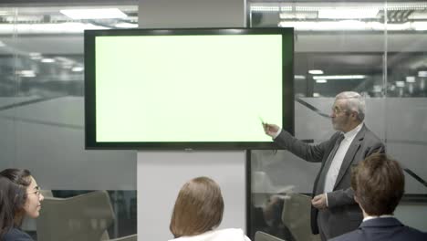 Confident-speaker-talking-with-colleagues-and-pointing-at-screen